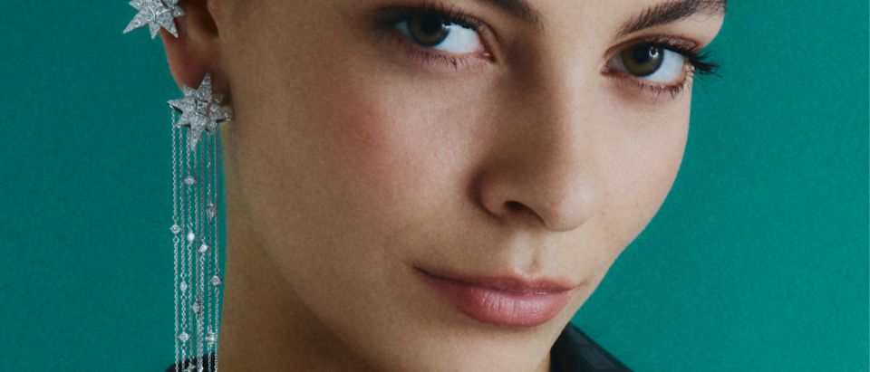 Yıldız formlu uzun küpe ve kolye takan model