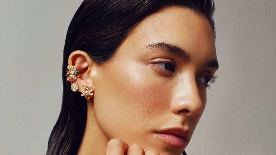 Kulağında arı motifli Bee Goddess ear cuff'lar, parmaklarında taşlı yüzükler olan model